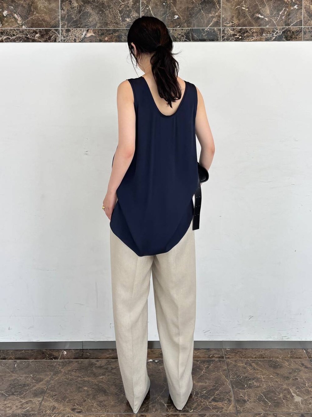 ブルー系のシャツ/ブラウス、ベージュ系のスラックスを着用したレディースの夏コーディネートの3枚目の写真