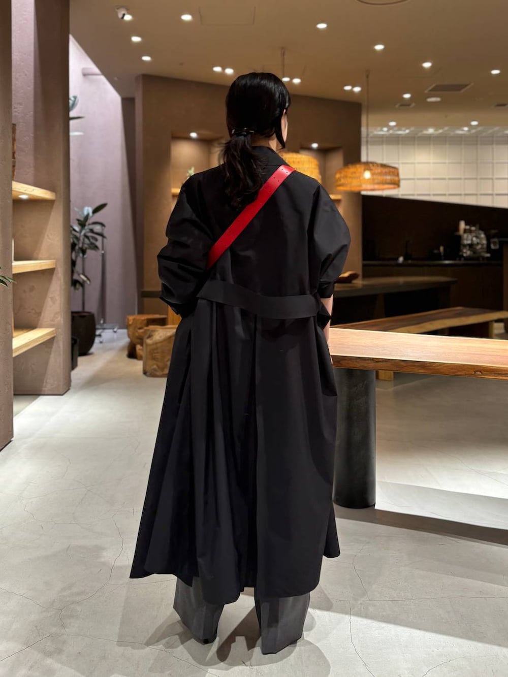 グレー系のスラックス、ホワイト系のカーディガン/ボレロ、ブラック系のトレンチコートを着用したレディースの冬コーディネートの2枚目の写真