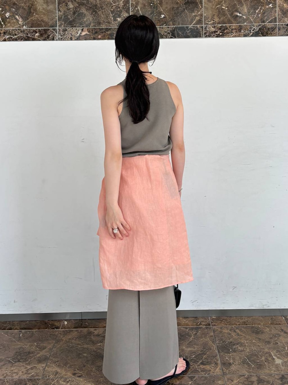 グレー系のタンクトップ、オレンジ系のシャツ/ブラウス、グレー系のネックレスを着用したレディースの夏コーディネートの4枚目の写真