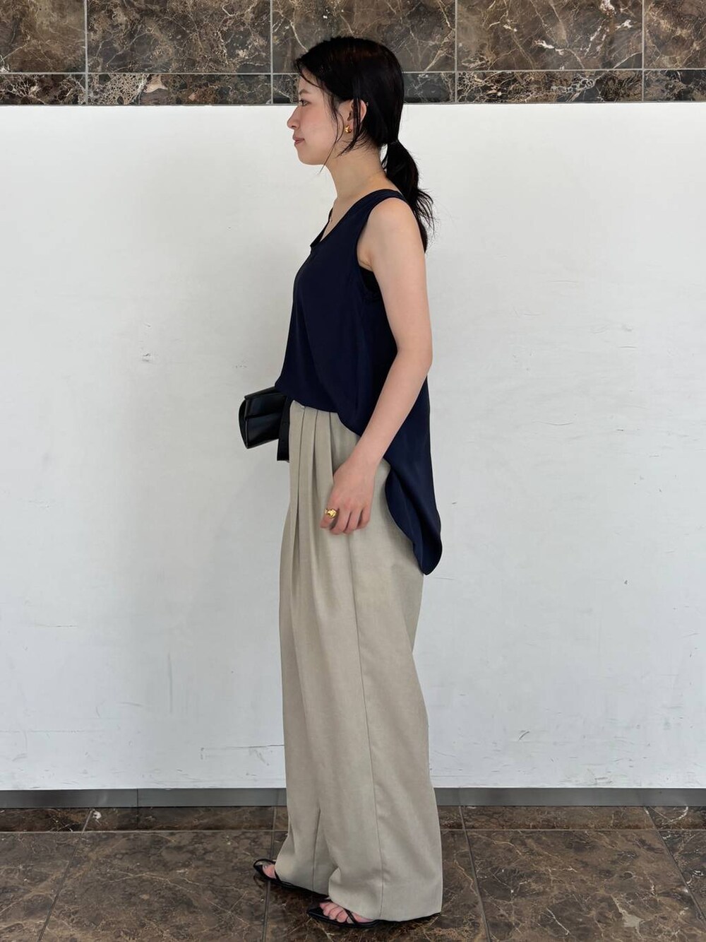 ブルー系のシャツ/ブラウス、ベージュ系のスラックスを着用したレディースの夏コーディネートの2枚目の写真