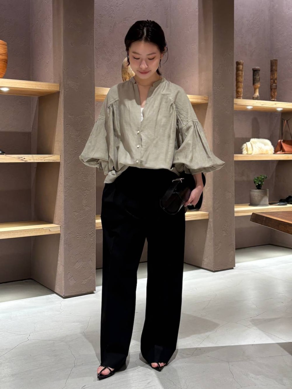 グリーン系のシャツ/ブラウス、ブラック系のスラックスを着用したレディースの春コーディネートの2枚目の写真