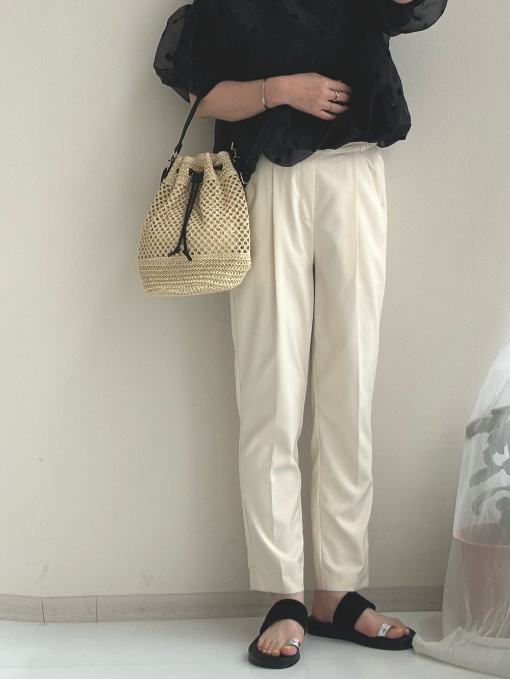 ブラック系のサンダル、ベージュ系のスラックス、ブラック系のTシャツ/カットソーを着用したレディースの夏コーディネートの3枚目の写真