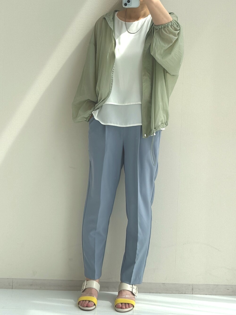ホワイト系のシャツ/ブラウス、グリーン系のブルゾン、ブルー系のスラックスを着用したレディースの春コーディネートの4枚目の写真