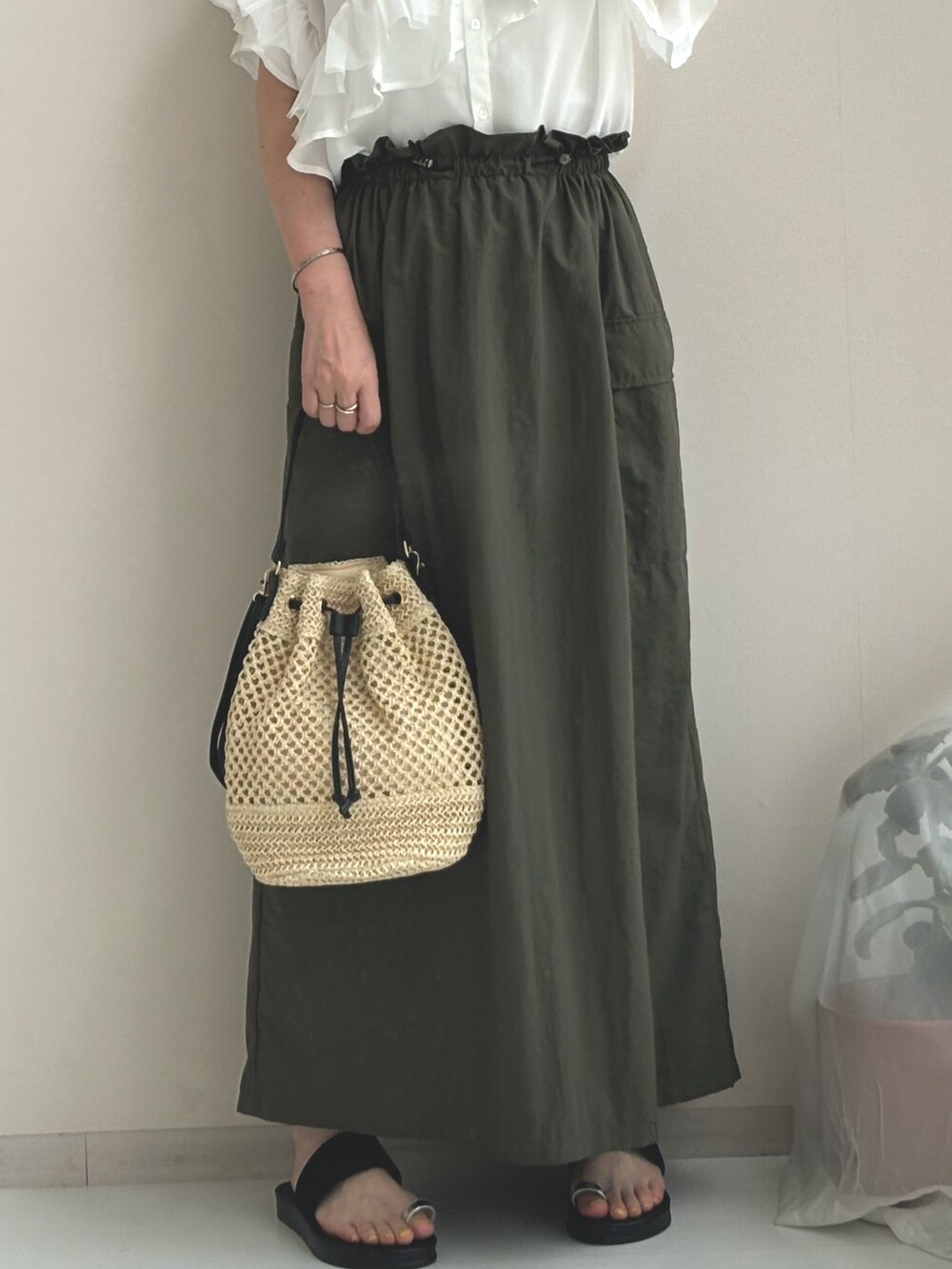 ホワイト系のシャツ/ブラウス、グリーン系のスカート、ブラック系のサンダルを着用したレディースの夏コーディネートの3枚目の写真