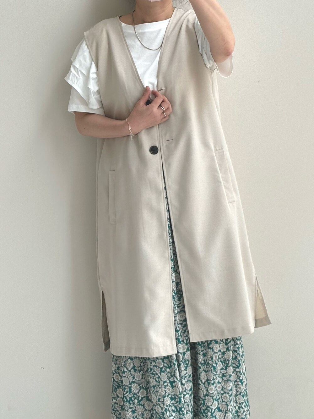 ホワイト系のベスト、グリーン系のその他パンツ、シルバー系のサンダルを着用したレディースの夏コーディネートの2枚目の写真