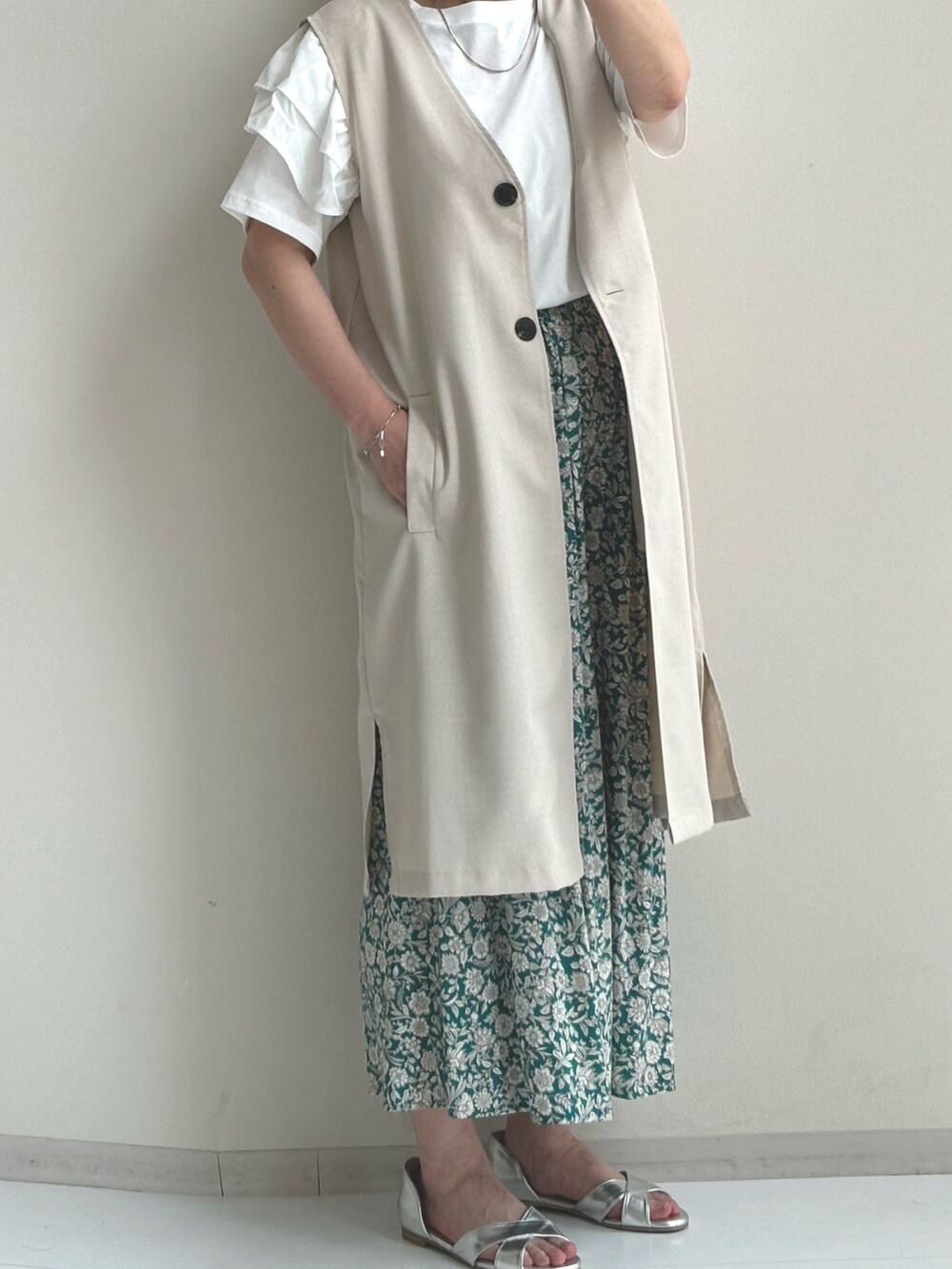 ホワイト系のベスト、グリーン系のその他パンツ、シルバー系のサンダルを着用したレディースの夏コーディネートの3枚目の写真