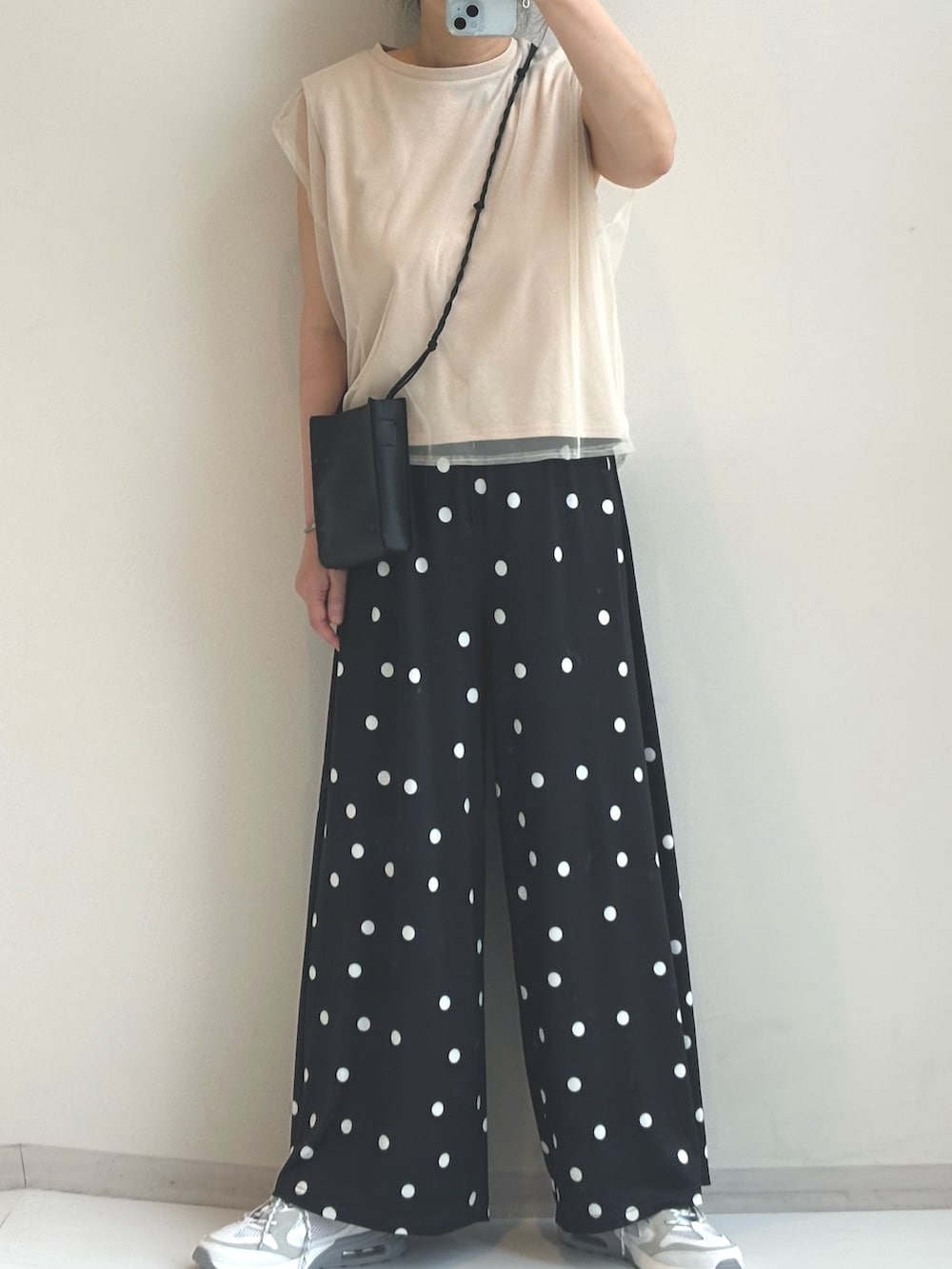 ベージュ系のTシャツ/カットソー、ブラック系のパンツを着用したレディースの春コーディネートの4枚目の写真