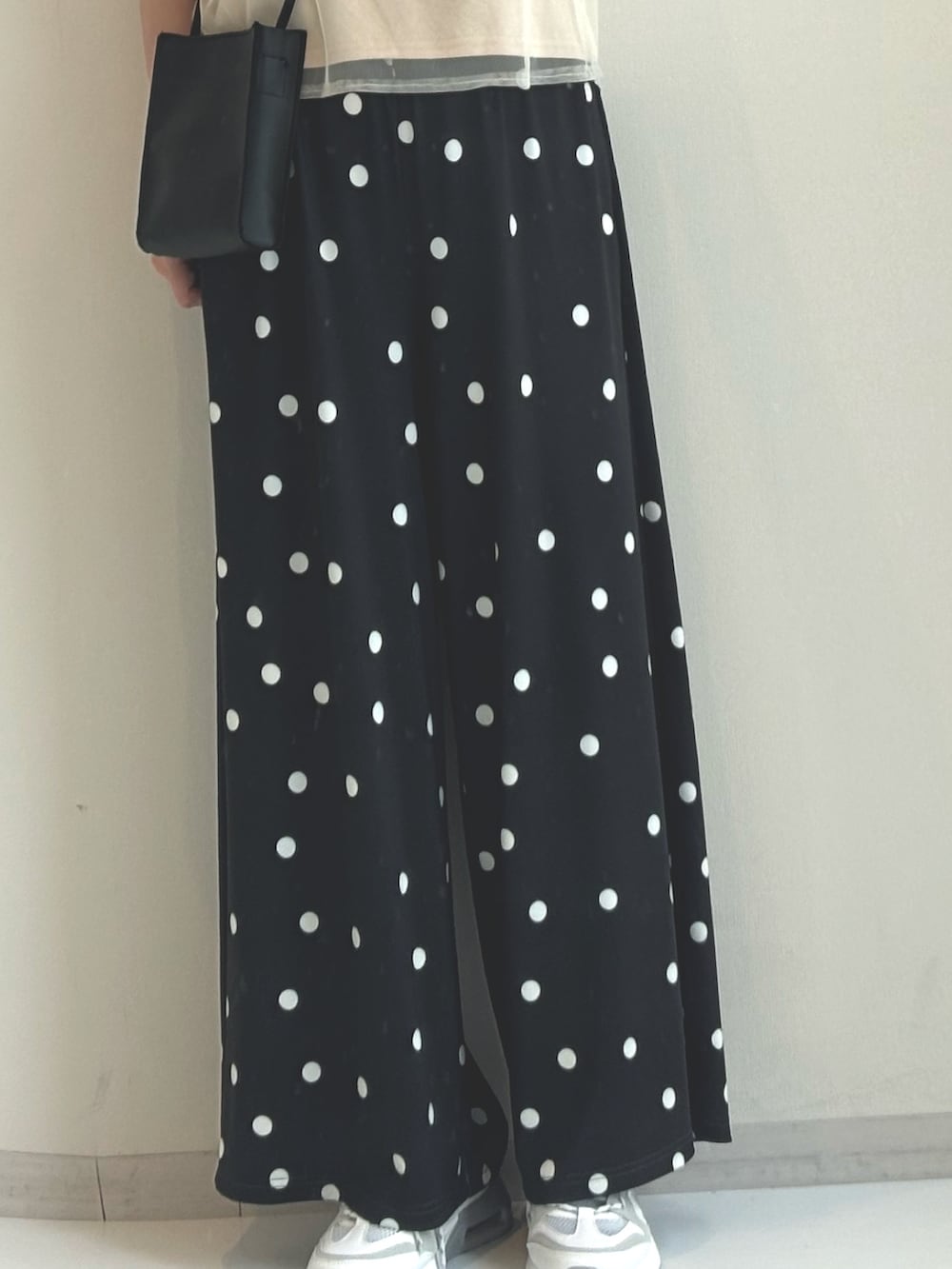 ベージュ系のTシャツ/カットソー、ブラック系のパンツを着用したレディースの春コーディネートの3枚目の写真