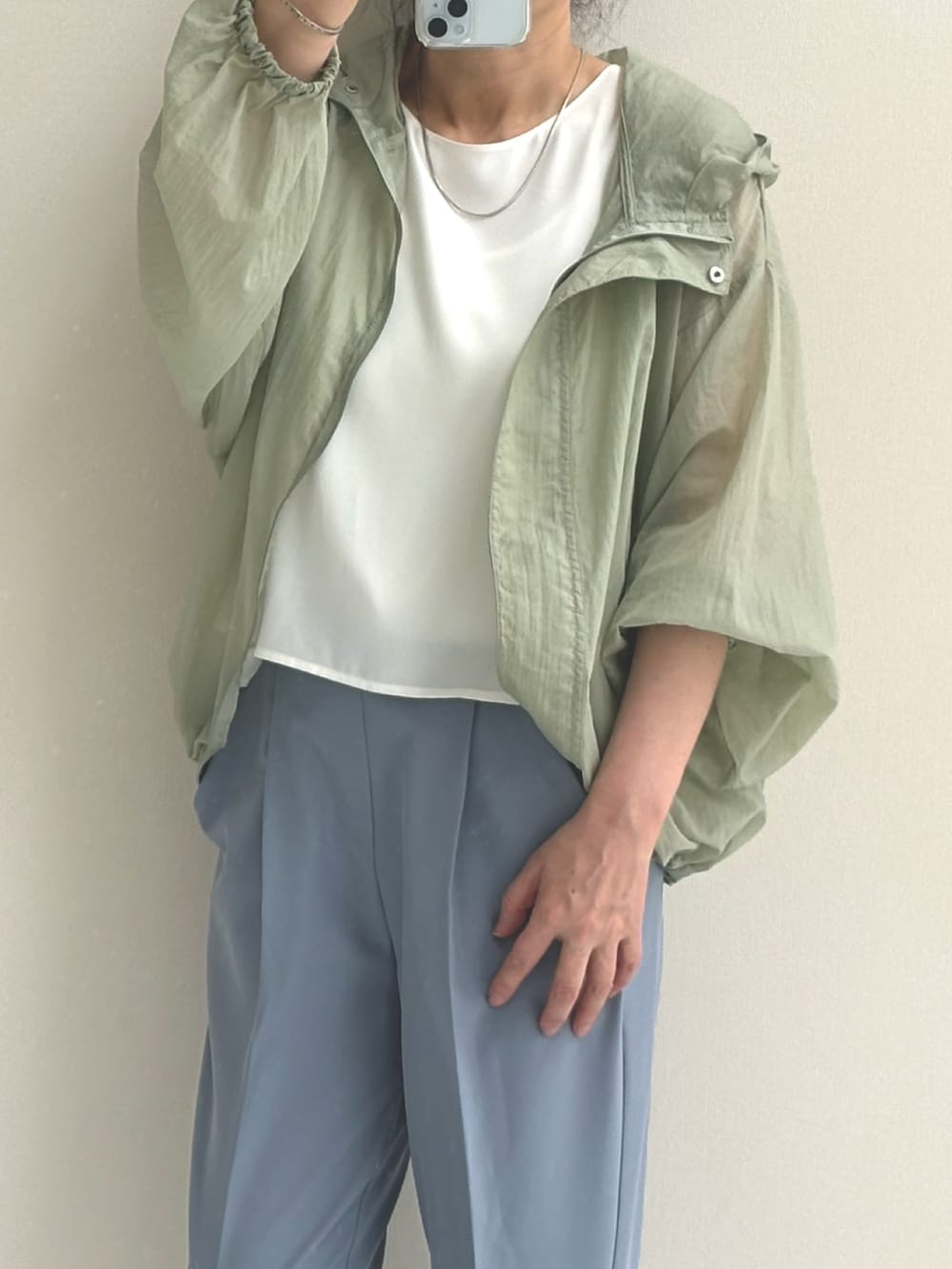 ホワイト系のシャツ/ブラウス、グリーン系のブルゾン、ブルー系のスラックスを着用したレディースの春コーディネートの2枚目の写真