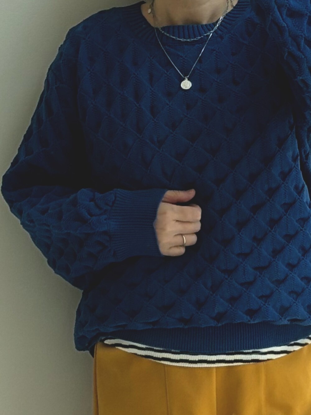 ブルー系のニット/セーター、イエロー系のパンツを着用したレディースの秋コーディネートの2枚目の写真