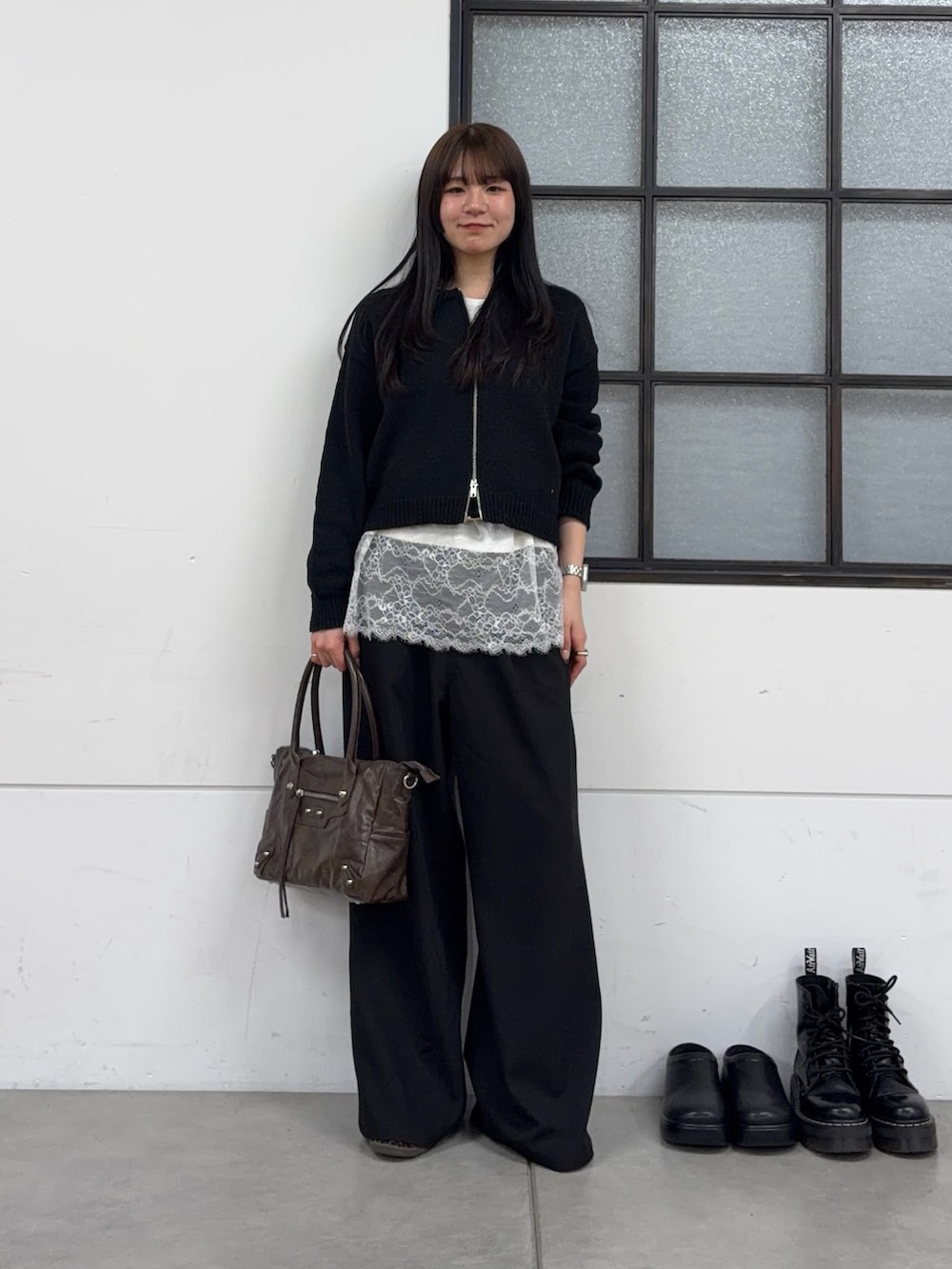 ブラウン系のショルダーバッグ、ブラック系のスラックス、ホワイト系のTシャツ/カットソーを着用したレディースの春コーディネートの4枚目の写真