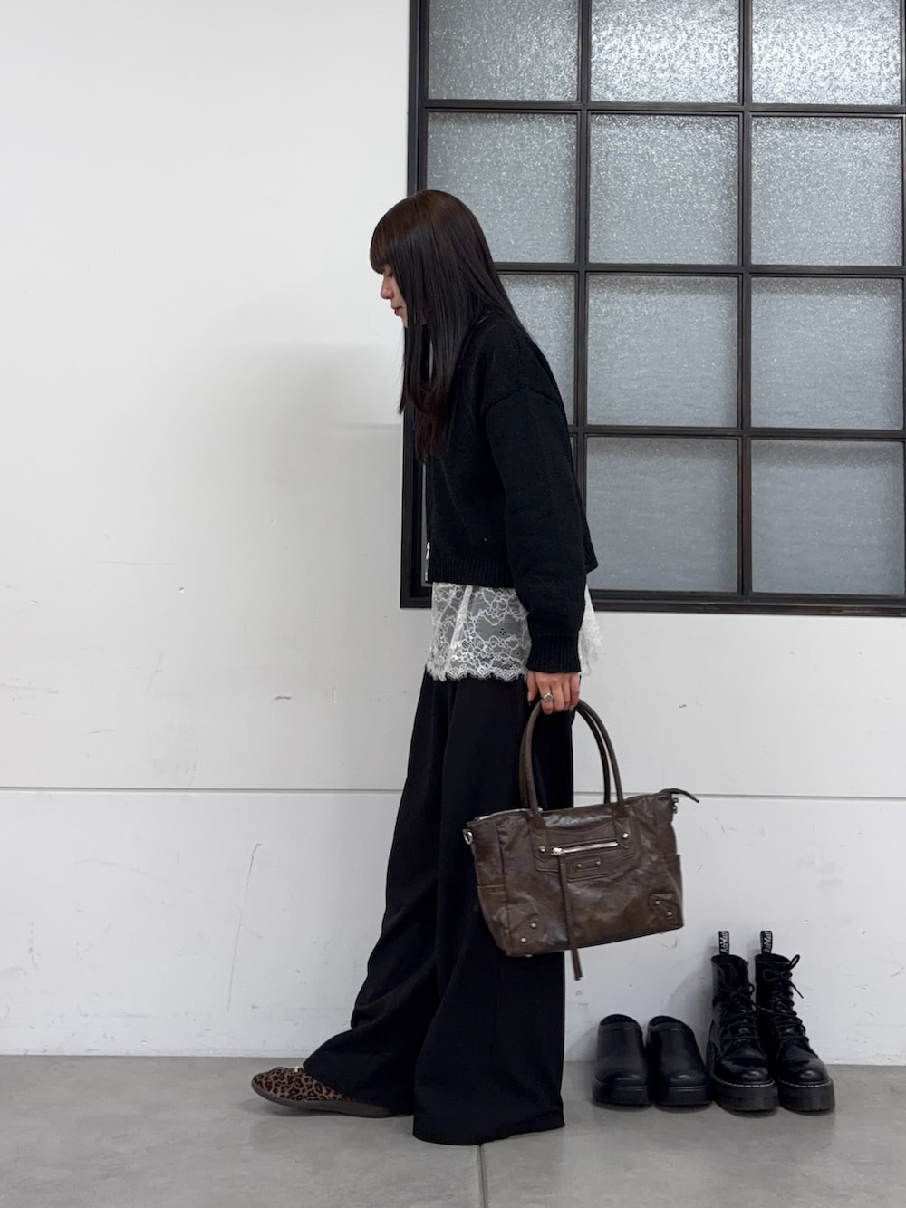 ブラウン系のショルダーバッグ、ブラック系のスラックス、ホワイト系のTシャツ/カットソーを着用したレディースの春コーディネートの3枚目の写真