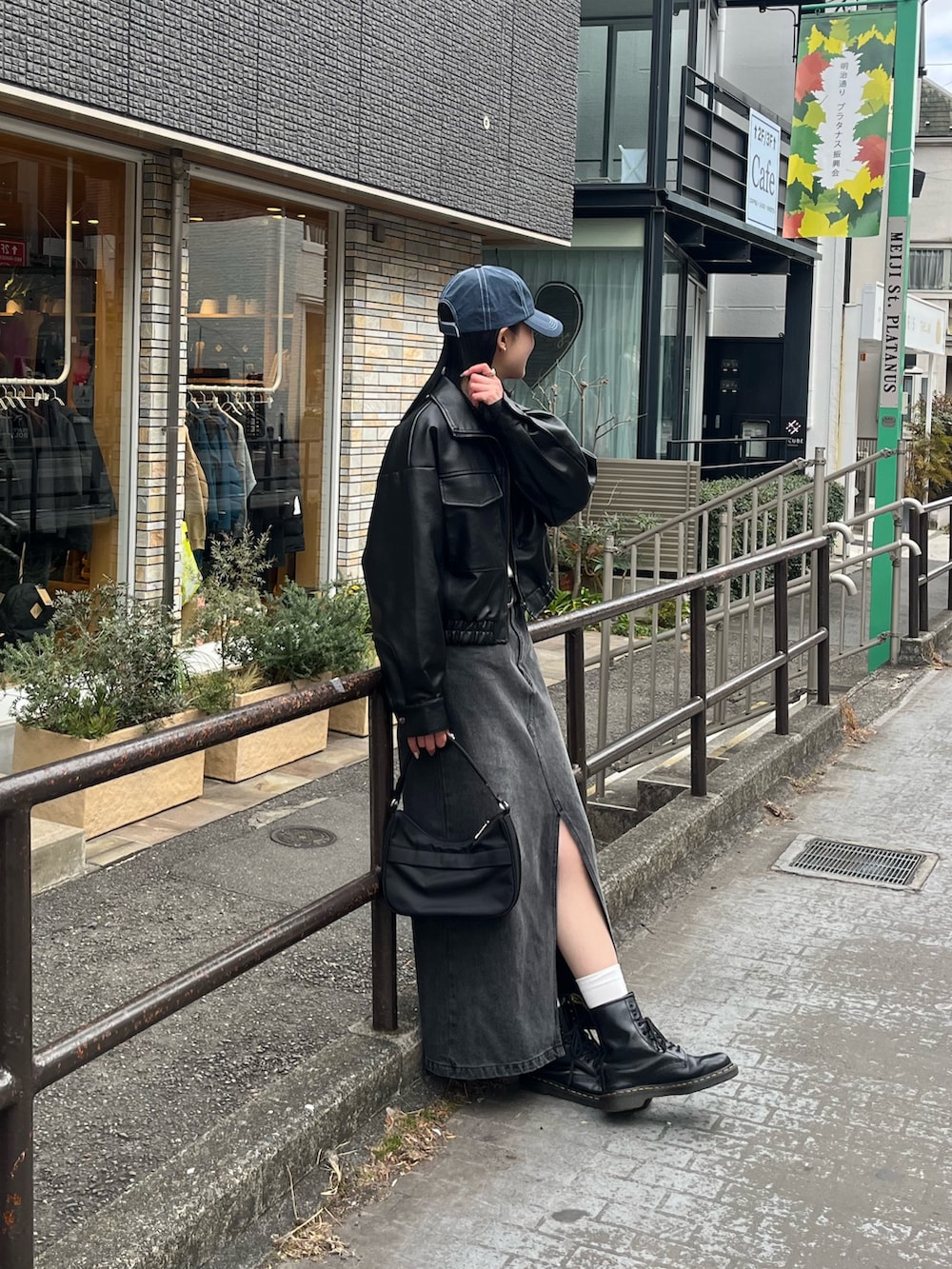 ブラック系のハンドバッグ、ブラック系のデニムスカート、ブラック系のライダースジャケットを着用したレディースの春コーディネートの3枚目の写真