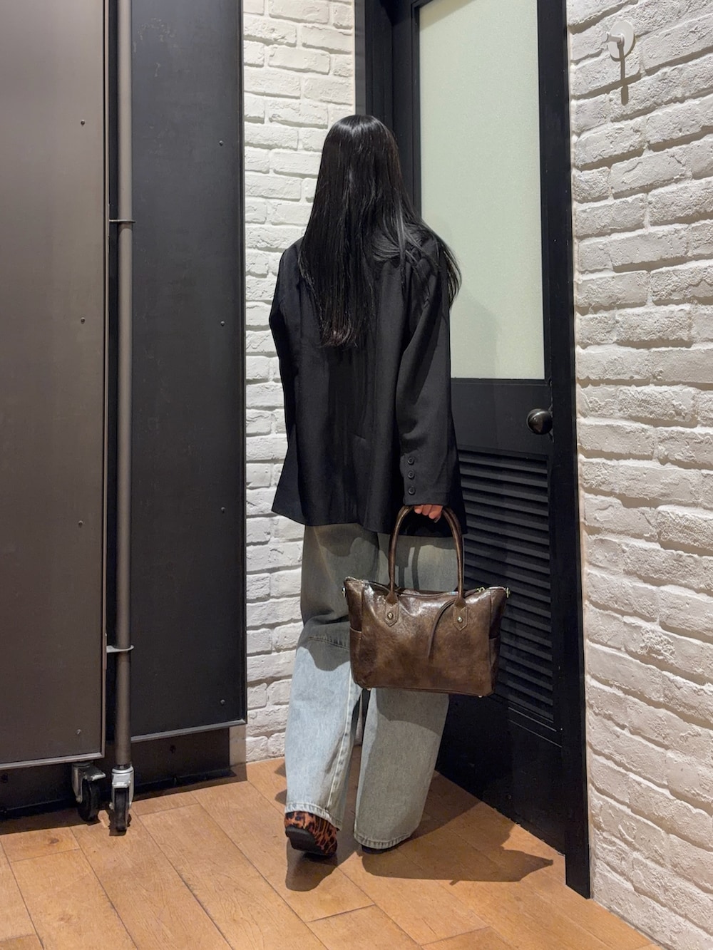 ブラウン系のショルダーバッグ、その他のバレエシューズ、ブルー系のデニムパンツを着用したレディースの春コーディネートの2枚目の写真