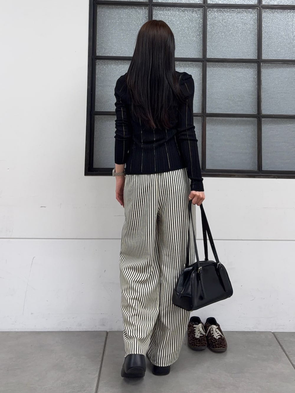 ブラック系のボストンバッグ、ブラック系のサンダル、ブルー系のその他パンツを着用したレディースの春コーディネートの3枚目の写真