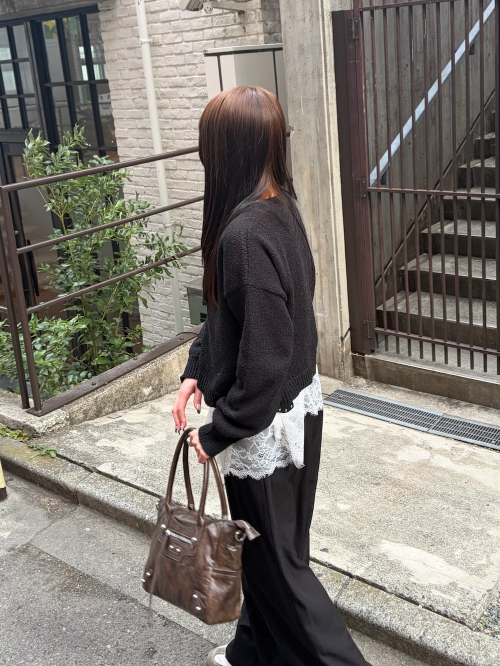 ホワイト系のTシャツ/カットソー、ブラック系のスラックス、ブラウン系のショルダーバッグを着用したレディースの春コーディネートの3枚目の写真