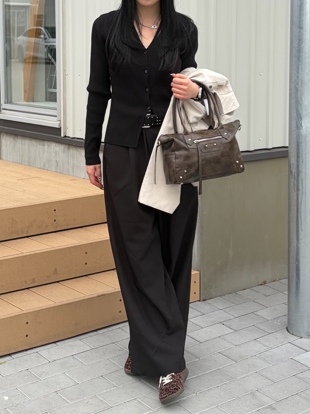 ブラウン系のショルダーバッグ、ブラック系のカーディガン/ボレロ、ブラック系のスラックスを着用したレディースの春コーディネートの3枚目の写真