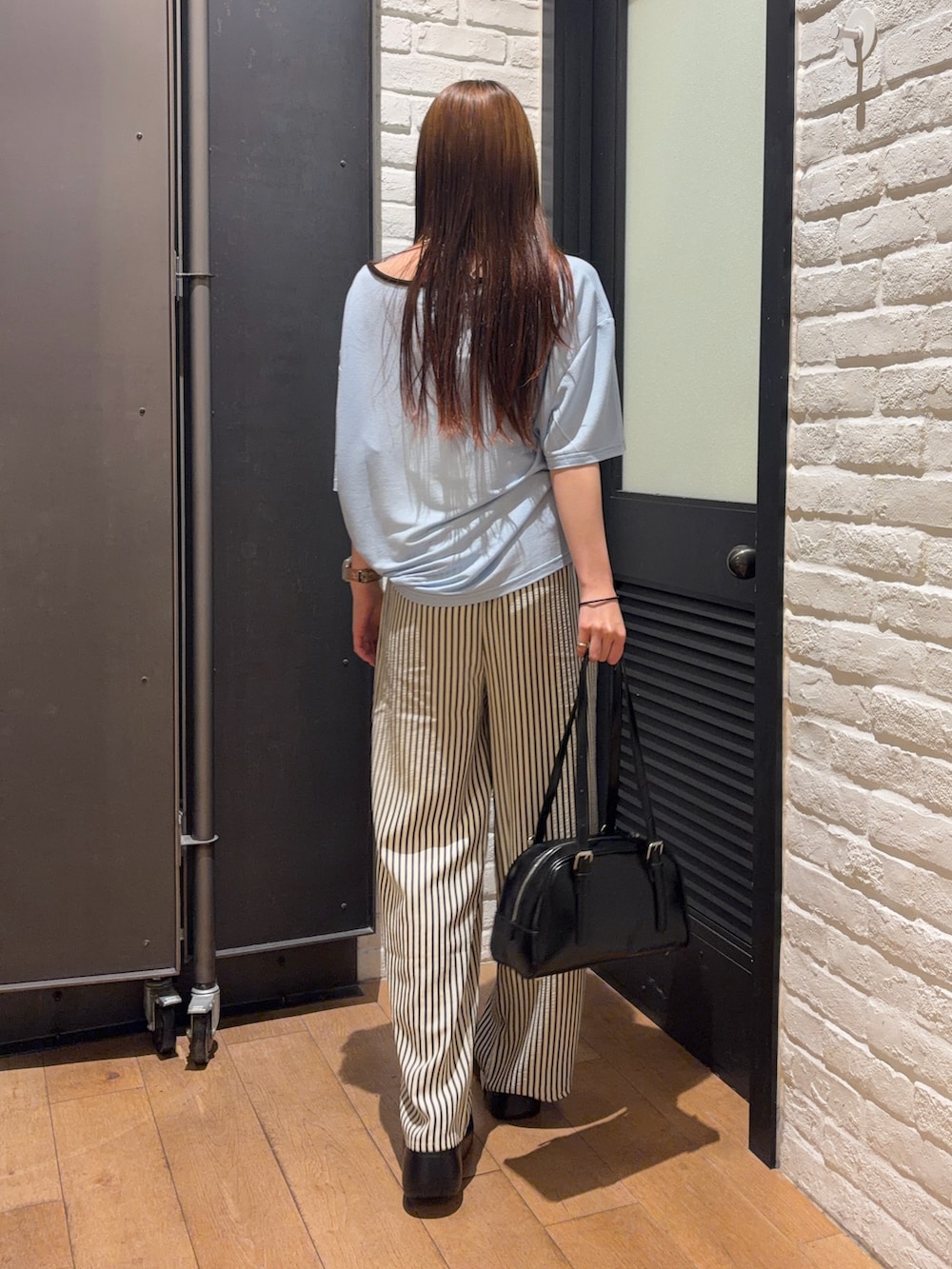ブルー系のその他パンツ、ブラック系のボストンバッグ、ブラック系のサンダルを着用したレディースの夏コーディネートの3枚目の写真