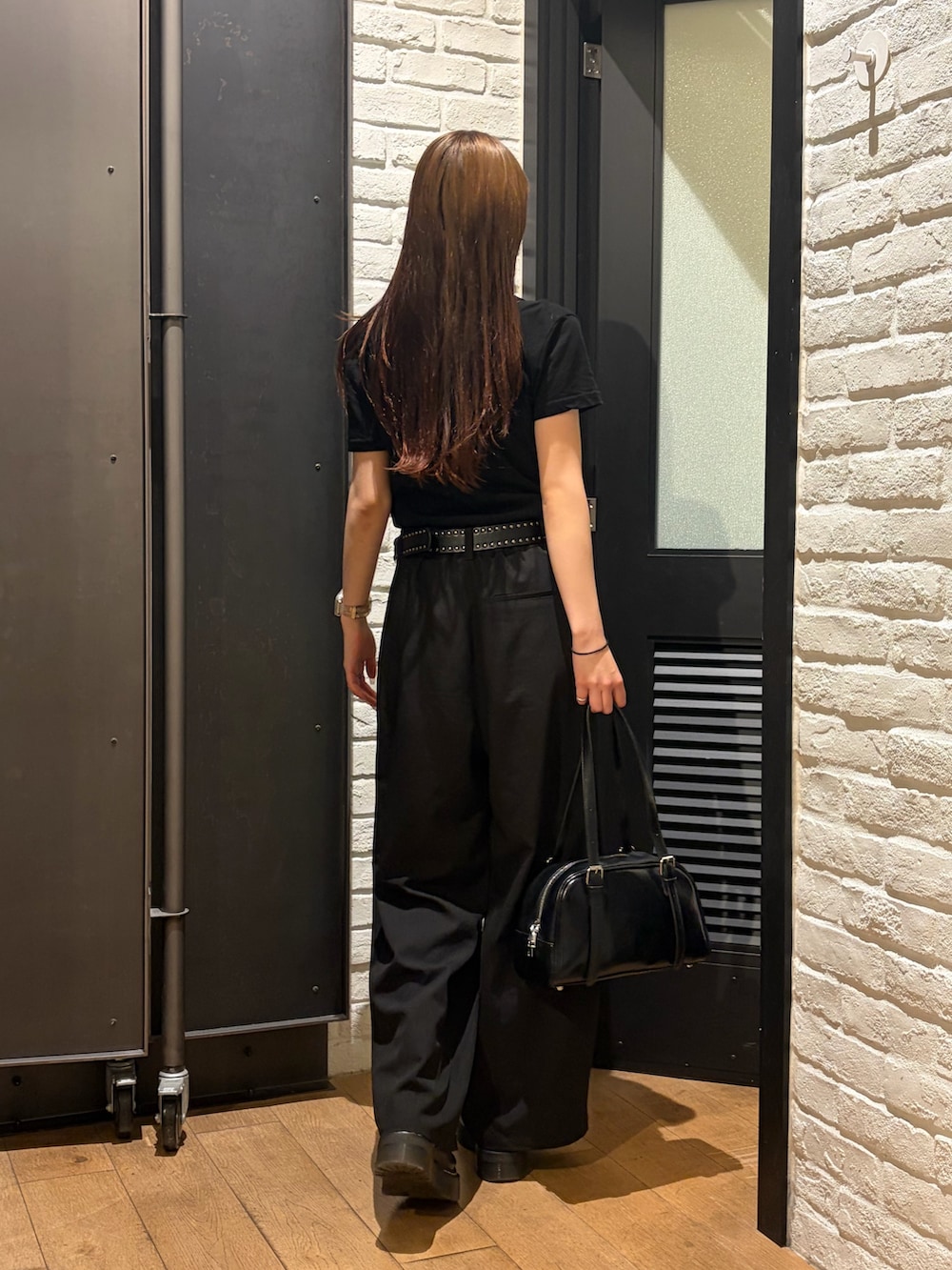 ブラック系のTシャツ/カットソー、ブラック系のボストンバッグ、ブラック系のスラックスを着用したレディースの夏コーディネートの3枚目の写真