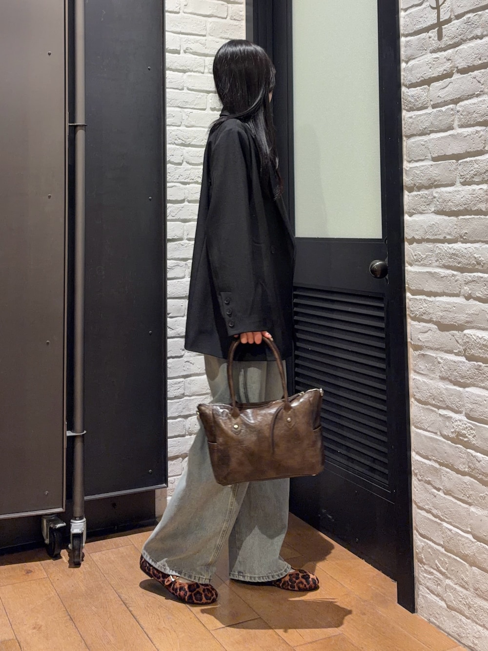 ブラウン系のショルダーバッグ、その他のバレエシューズ、ブルー系のデニムパンツを着用したレディースの春コーディネートの3枚目の写真