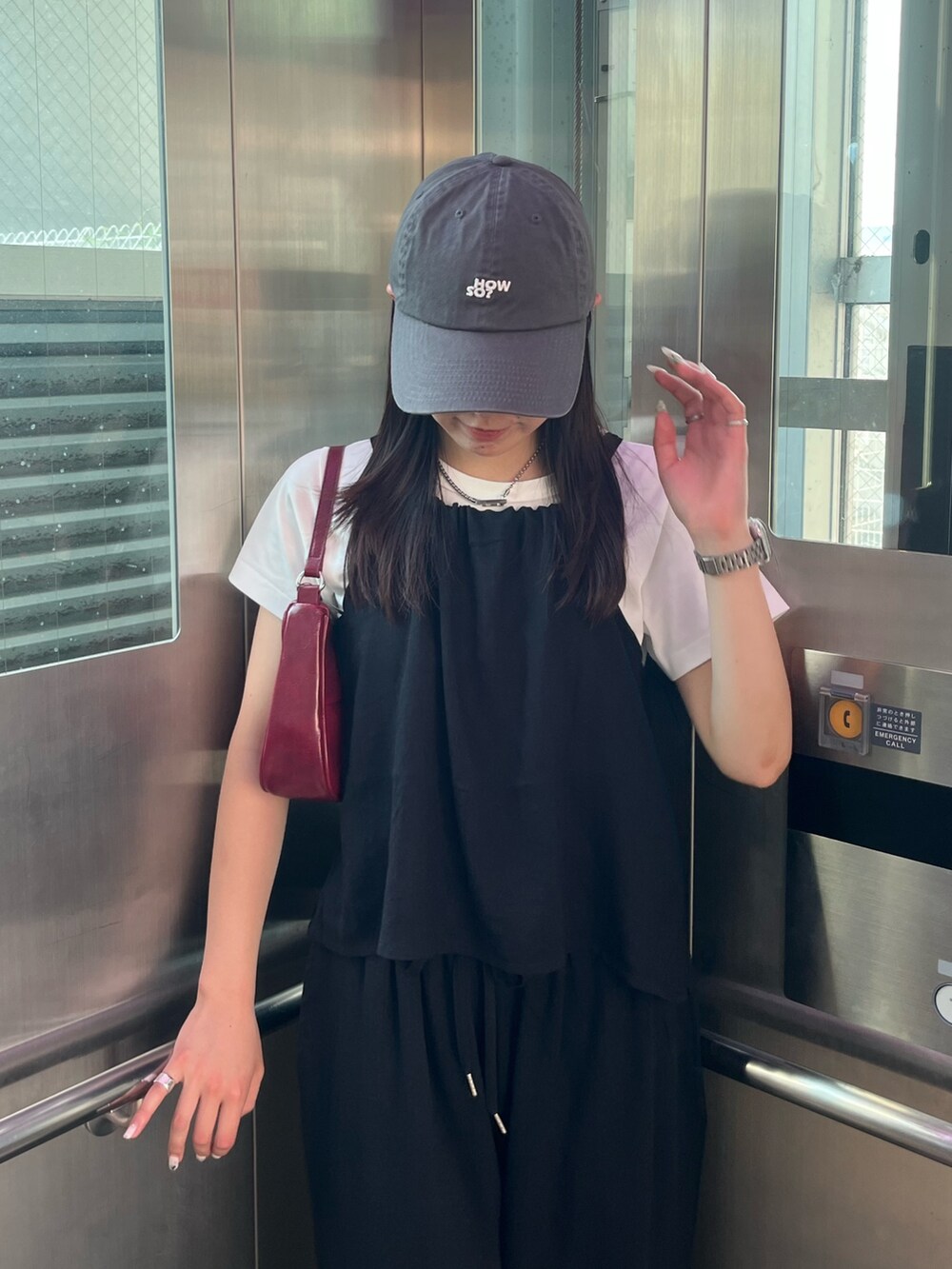 ブラック系のキャミソール、ホワイト系のTシャツ/カットソー、レッド系のハンドバッグを着用したレディースの夏コーディネートの2枚目の写真