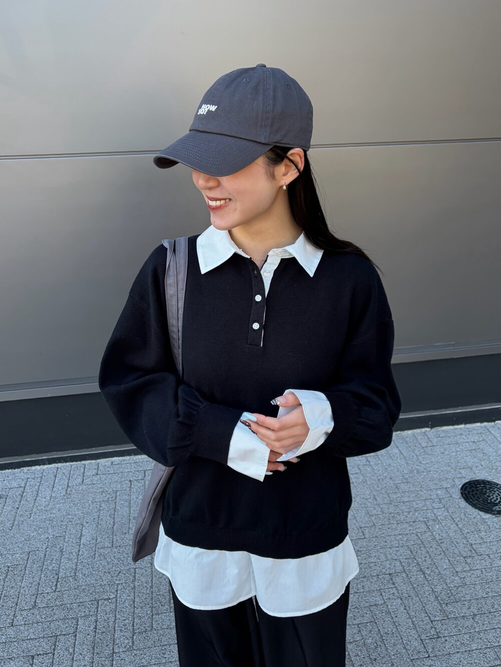 ブラック系のスラックス、グレー系のトートバッグ、ブラック系のニット/セーターを着用したレディースの冬コーディネートの2枚目の写真