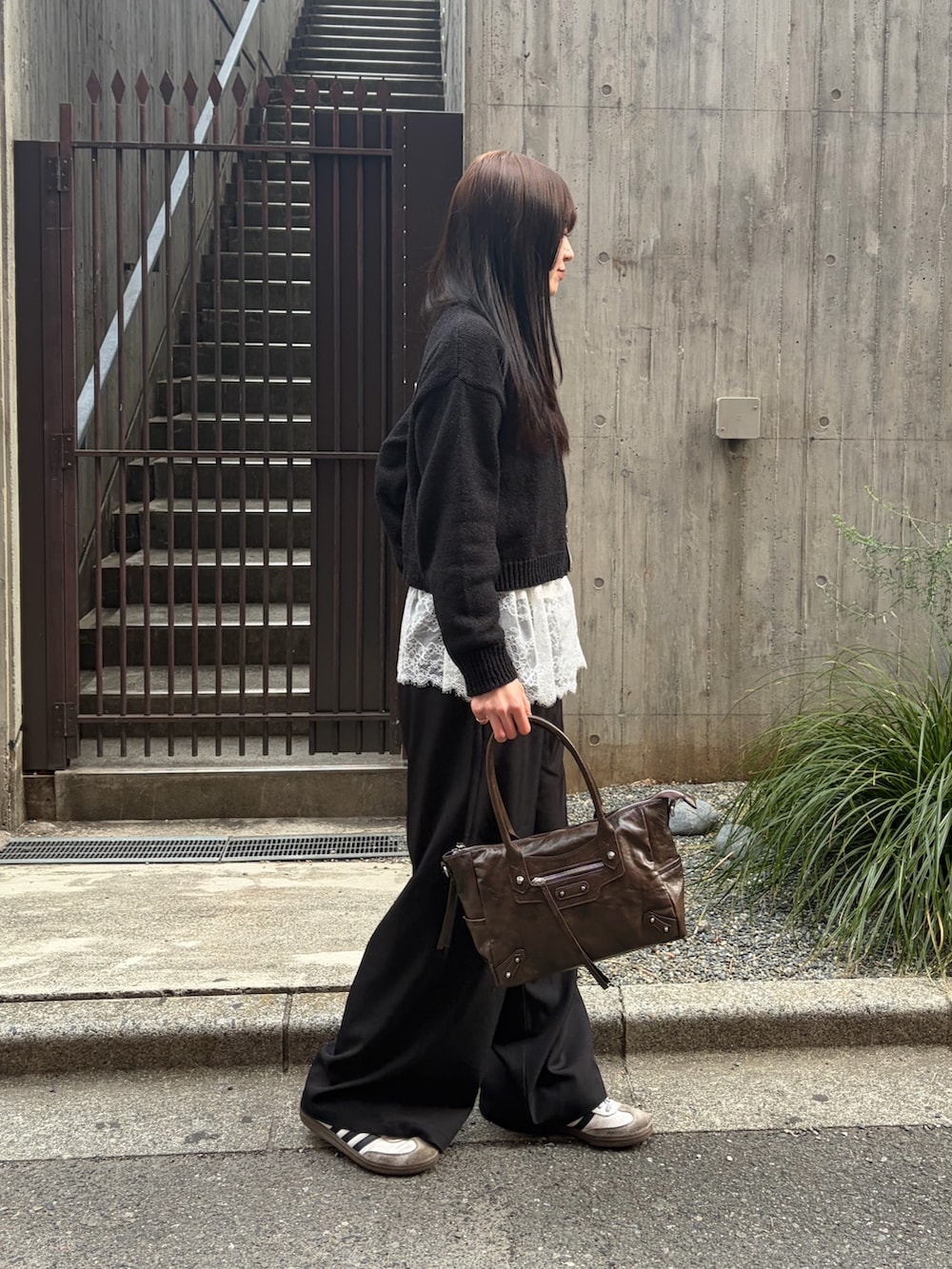 ホワイト系のTシャツ/カットソー、ブラック系のスラックス、ブラウン系のショルダーバッグを着用したレディースの春コーディネートの6枚目の写真
