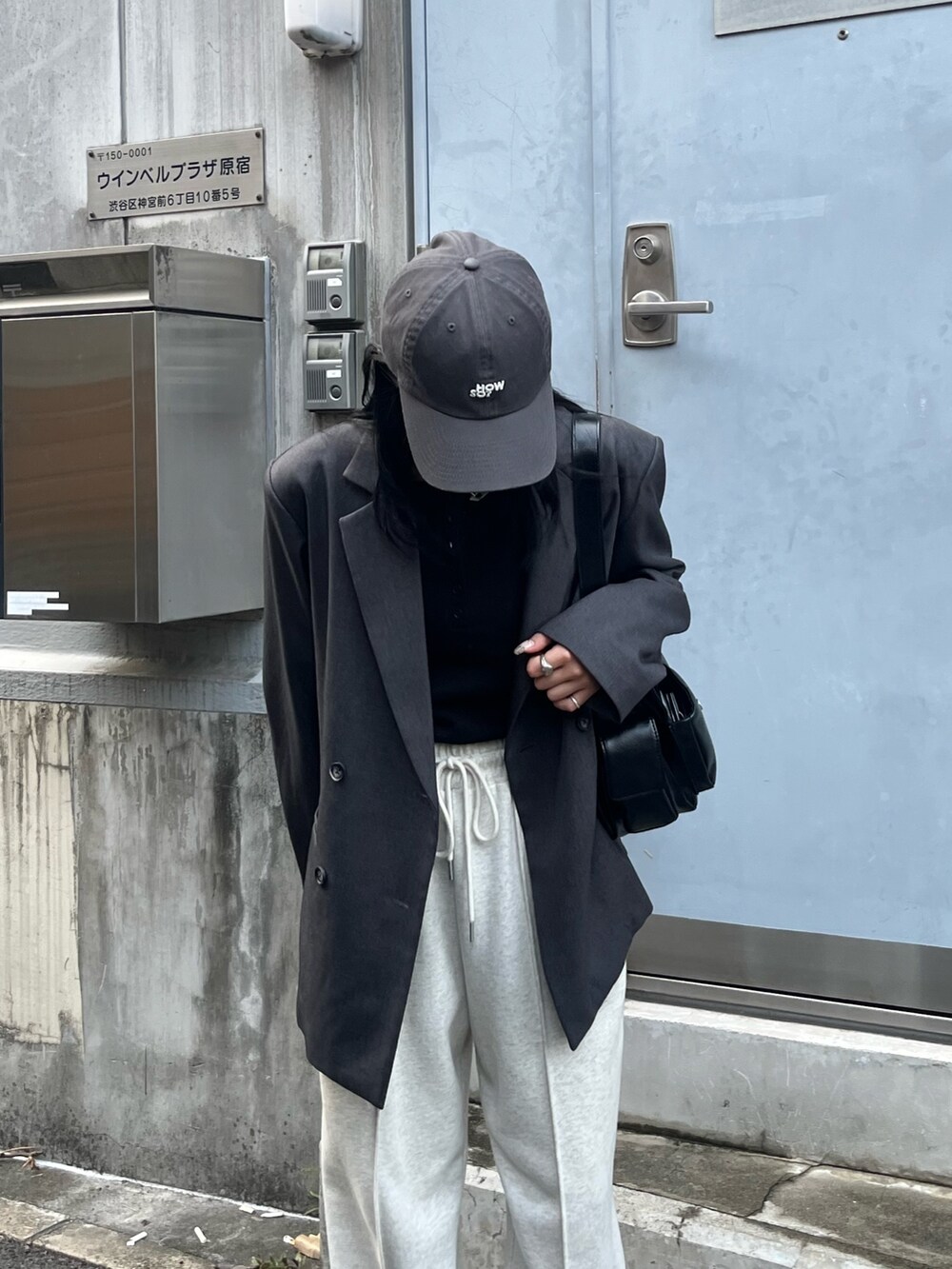 ホワイト系のスウェットパンツ、ブラック系のショルダーバッグ、ブラック系のTシャツ/カットソーを着用したレディースの秋コーディネートの3枚目の写真