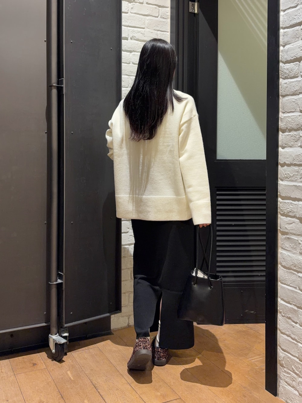 ホワイト系のニット/セーター、ブラック系のスカート、ブラック系のショルダーバッグを着用したレディースの冬コーディネートの2枚目の写真