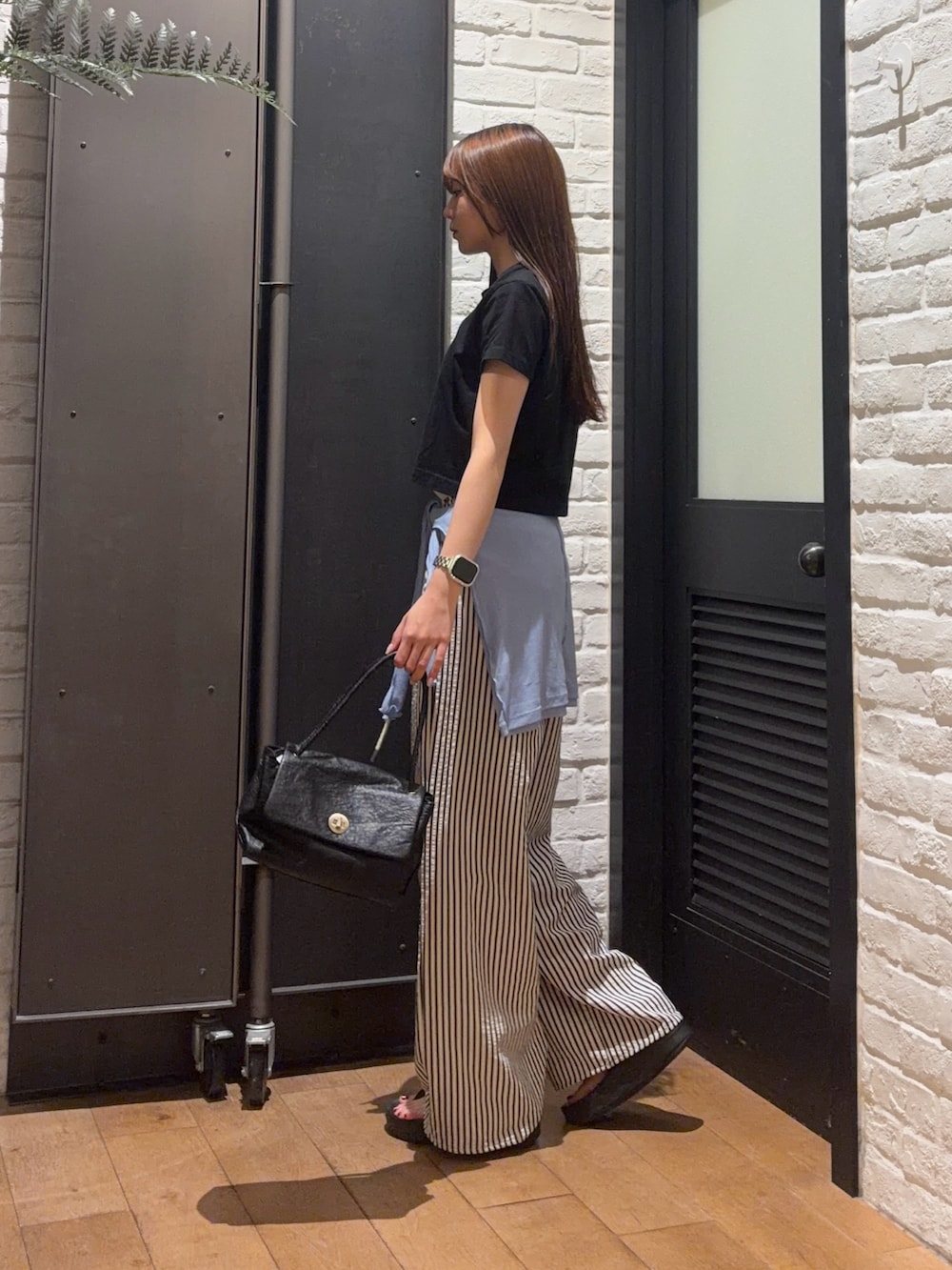ブラック系のTシャツ/カットソー、ブラック系のハンドバッグ、ブルー系のその他パンツを着用したレディースの夏コーディネートの3枚目の写真