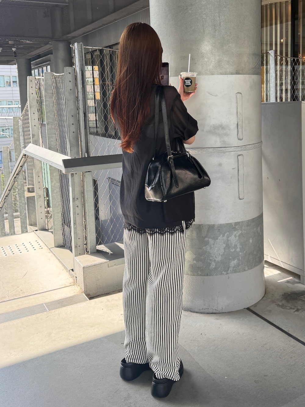 ブラック系のサンダル、ブルー系のその他パンツ、ブラック系のシャツ/ブラウスを着用したレディースの夏コーディネートの4枚目の写真