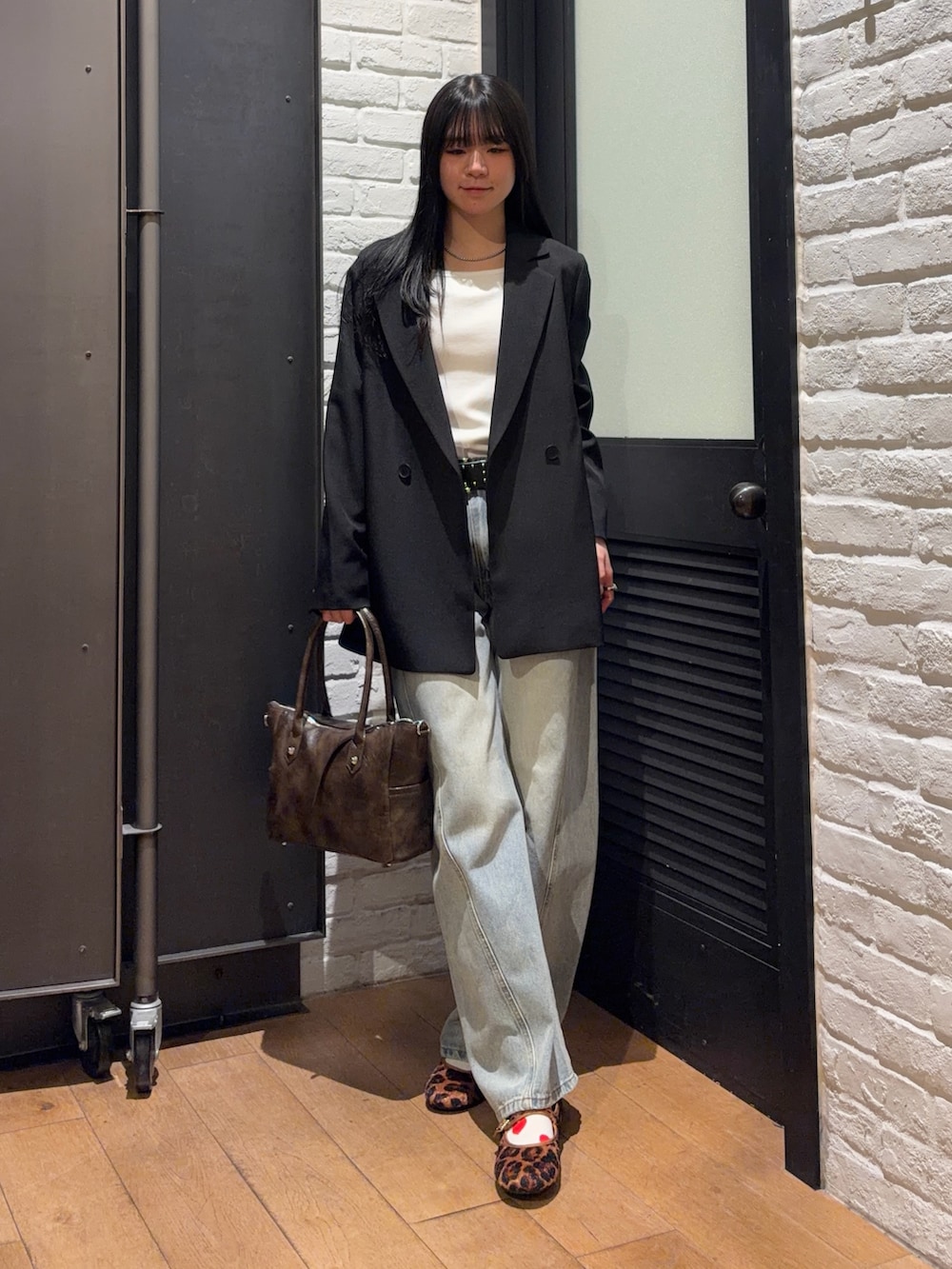 ブラウン系のショルダーバッグ、その他のバレエシューズ、ブルー系のデニムパンツを着用したレディースの春コーディネートの4枚目の写真