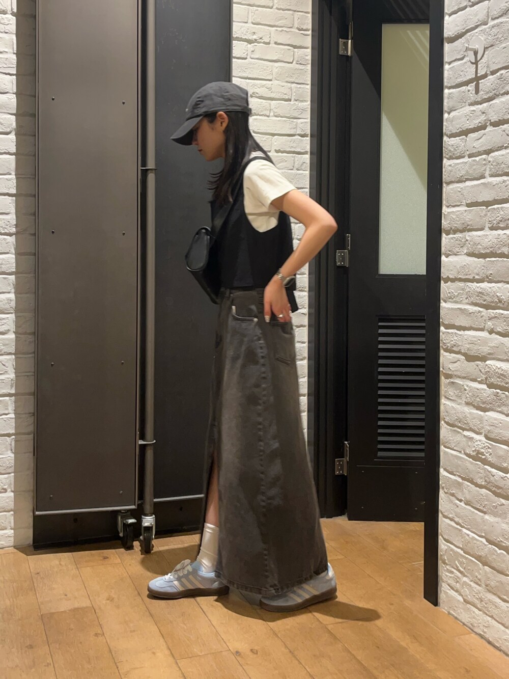 ホワイト系のTシャツ/カットソー、ブラック系のデニムスカート、ブラック系のボディバッグ/ウエストポーチを着用したレディースの夏コーディネートの4枚目の写真