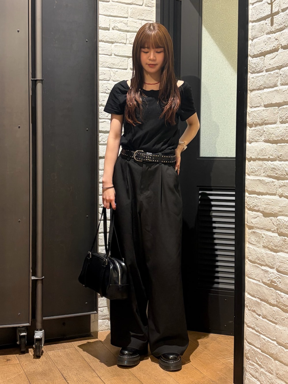 ブラック系のTシャツ/カットソー、ブラック系のボストンバッグ、ブラック系のスラックスを着用したレディースの夏コーディネートの2枚目の写真