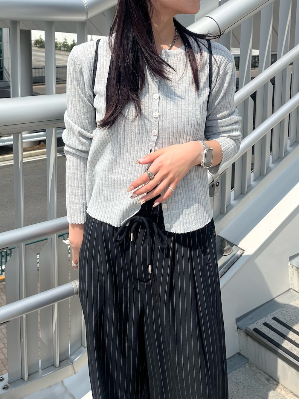 ブラック系のスラックス、ブラック系のキャミソール、グレー系のカーディガン/ボレロを着用したレディースの秋コーディネートの3枚目の写真