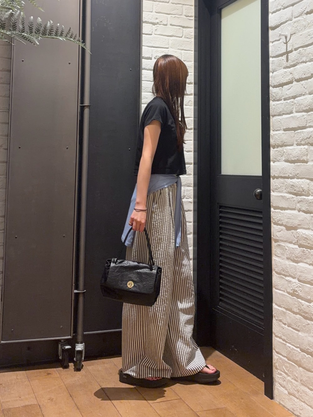 ブラック系のTシャツ/カットソー、ブラック系のハンドバッグ、ブルー系のその他パンツを着用したレディースの夏コーディネートの4枚目の写真