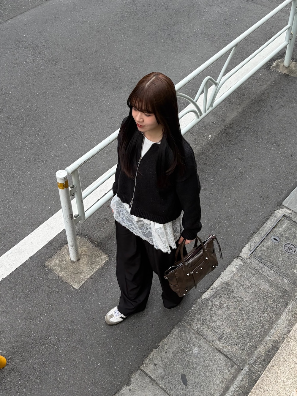 ホワイト系のTシャツ/カットソー、ブラック系のスラックス、ブラウン系のショルダーバッグを着用したレディースの春コーディネートの2枚目の写真