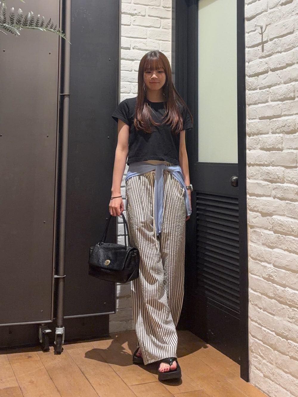 ブラック系のTシャツ/カットソー、ブラック系のハンドバッグ、ブルー系のその他パンツを着用したレディースの夏コーディネートの5枚目の写真