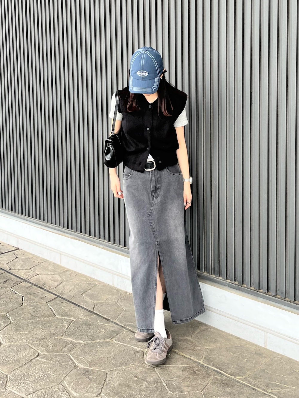 ブラック系のベスト、グレー系のTシャツ/カットソー、ブラック系のハンドバッグを着用したレディースの春コーディネートの4枚目の写真