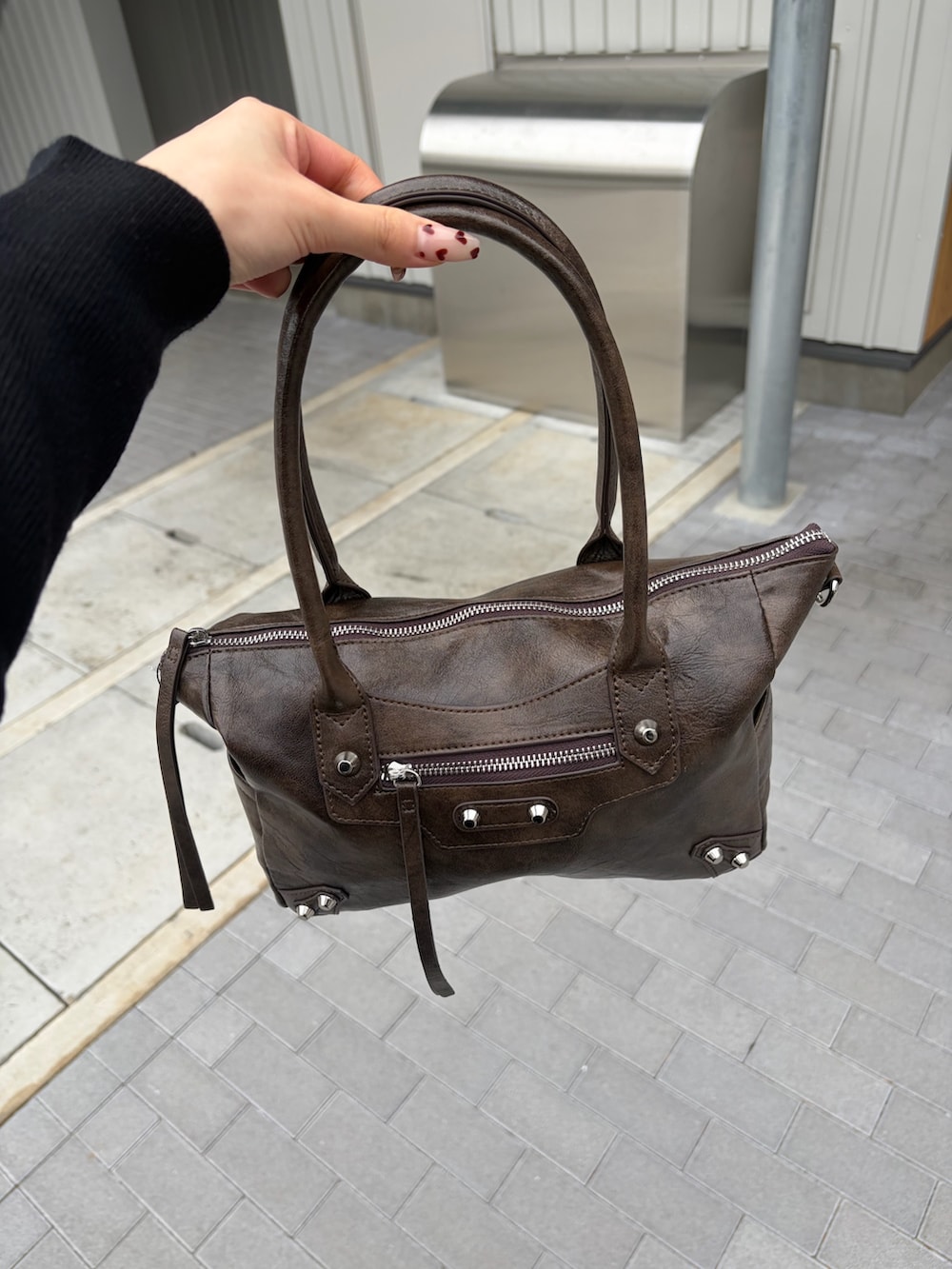 ブラウン系のショルダーバッグ、ブラック系のカーディガン/ボレロ、ブラック系のスラックスを着用したレディースの春コーディネートの4枚目の写真