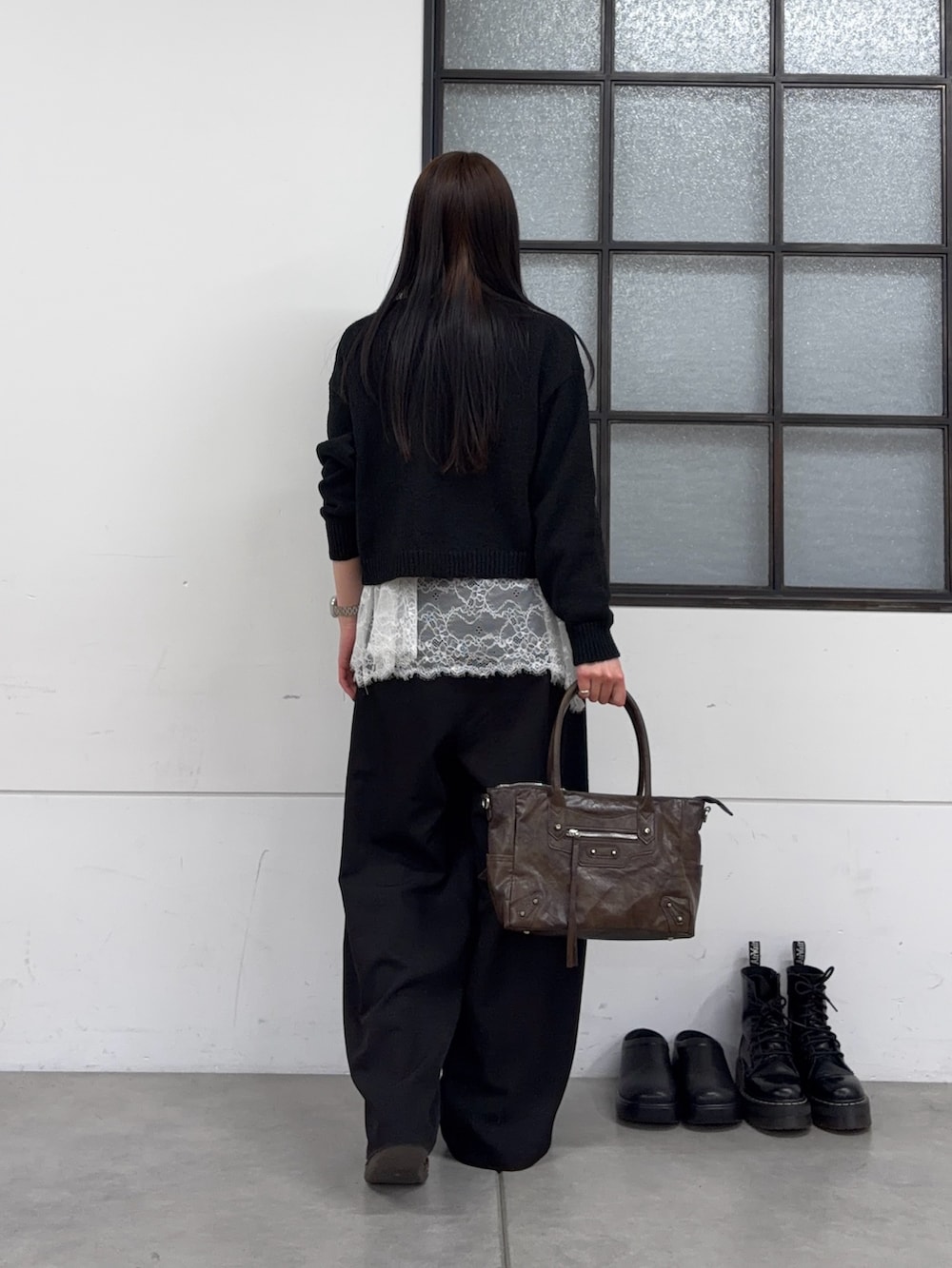 ブラウン系のショルダーバッグ、ブラック系のスラックス、ホワイト系のTシャツ/カットソーを着用したレディースの春コーディネートの2枚目の写真