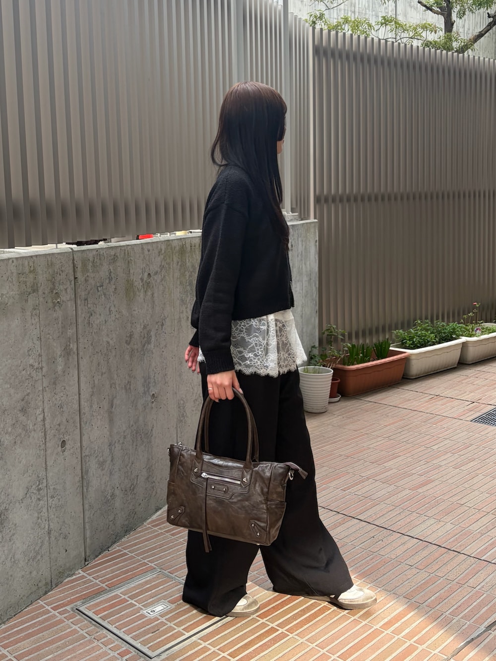 ホワイト系のTシャツ/カットソー、ブラック系のスラックス、ブラウン系のショルダーバッグを着用したレディースの春コーディネートの4枚目の写真