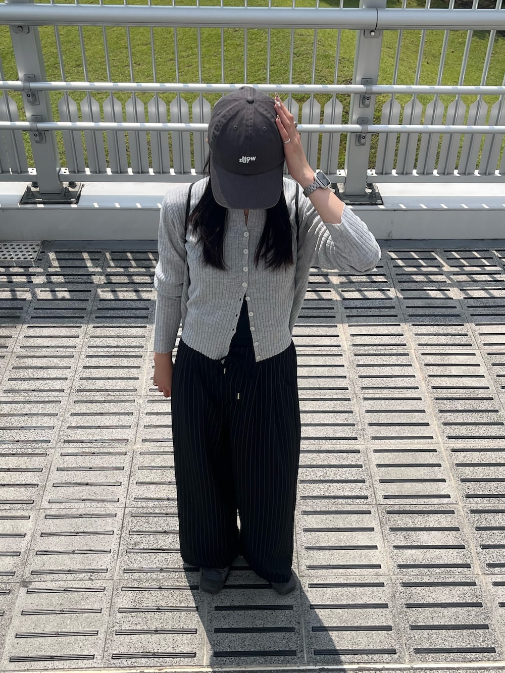 ブラック系のスラックス、ブラック系のキャミソール、グレー系のカーディガン/ボレロを着用したレディースの秋コーディネートの2枚目の写真