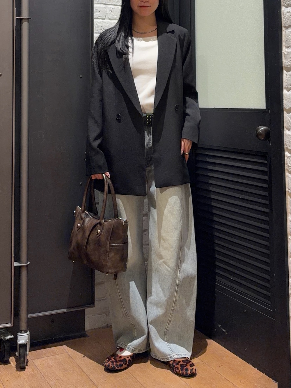 ブラウン系のショルダーバッグ、その他のバレエシューズ、ブルー系のデニムパンツを着用したレディースの春コーディネートの5枚目の写真