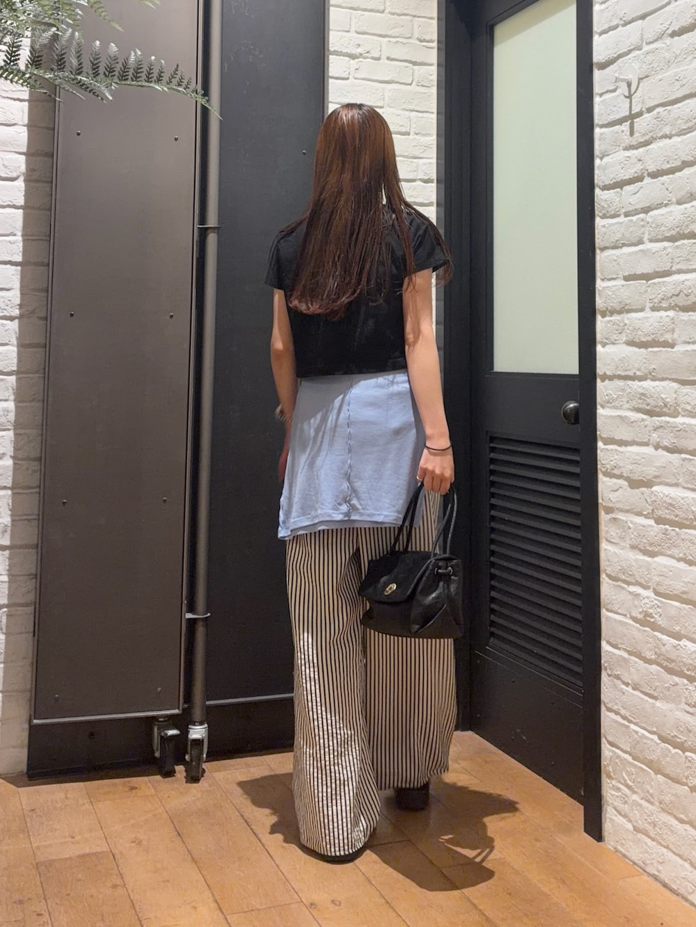 ブラック系のTシャツ/カットソー、ブラック系のハンドバッグ、ブルー系のその他パンツを着用したレディースの夏コーディネートの2枚目の写真