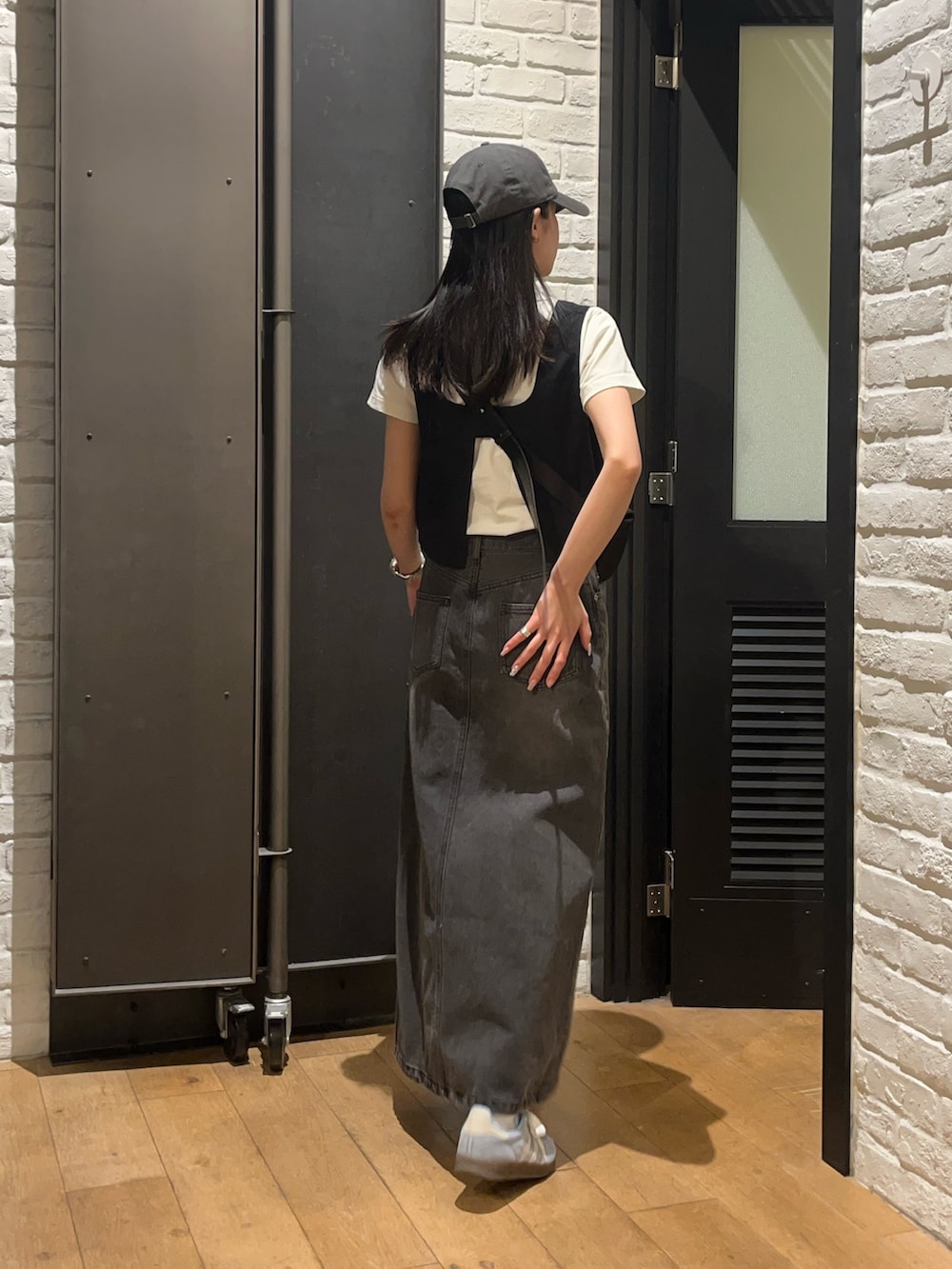 ホワイト系のTシャツ/カットソー、ブラック系のデニムスカート、ブラック系のボディバッグ/ウエストポーチを着用したレディースの夏コーディネートの2枚目の写真