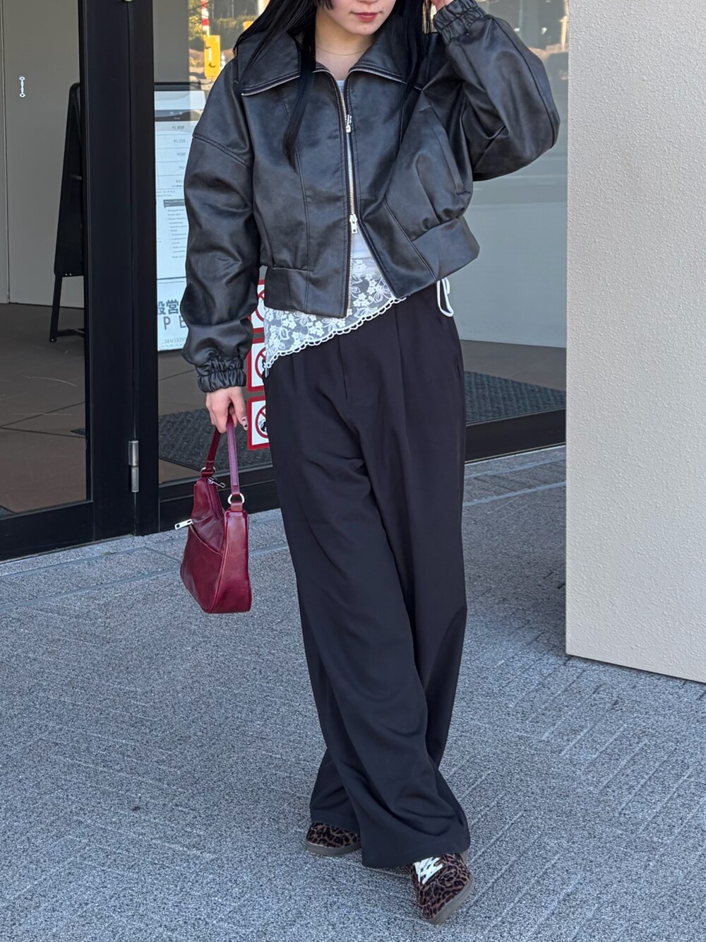 レッド系のハンドバッグ、ブラック系のスラックス、ホワイト系のTシャツ/カットソーを着用したレディースの冬コーディネートの3枚目の写真