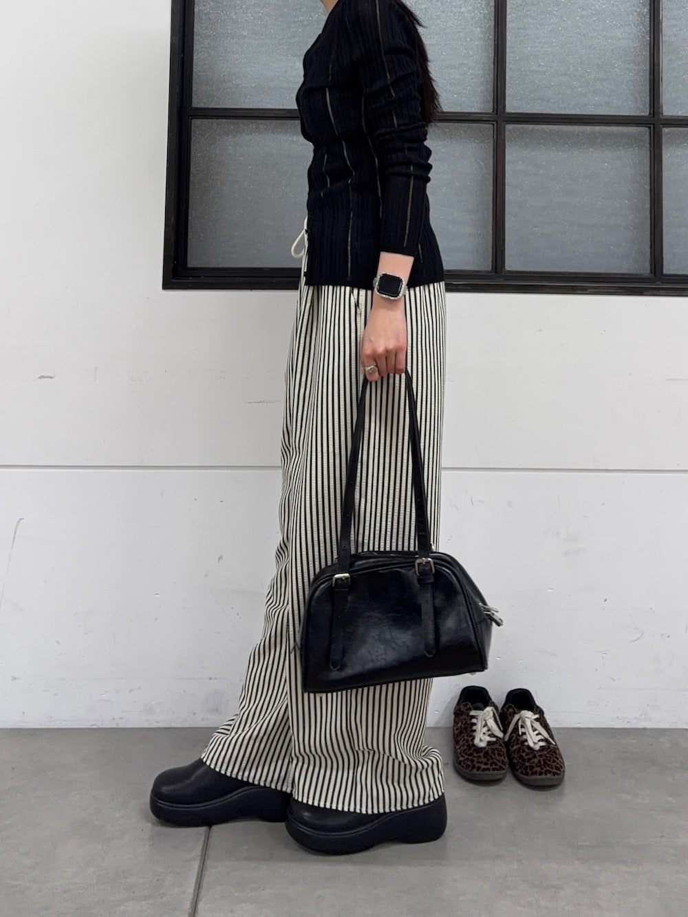 ブラック系のボストンバッグ、ブラック系のサンダル、ブルー系のその他パンツを着用したレディースの春コーディネートの4枚目の写真