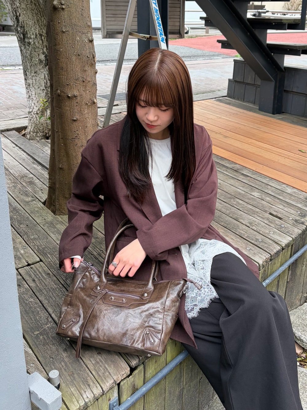 ブラウン系のショルダーバッグ、ホワイト系のTシャツ/カットソー、ブラウン系のテーラードジャケットを着用したレディースの春コーディネートの2枚目の写真