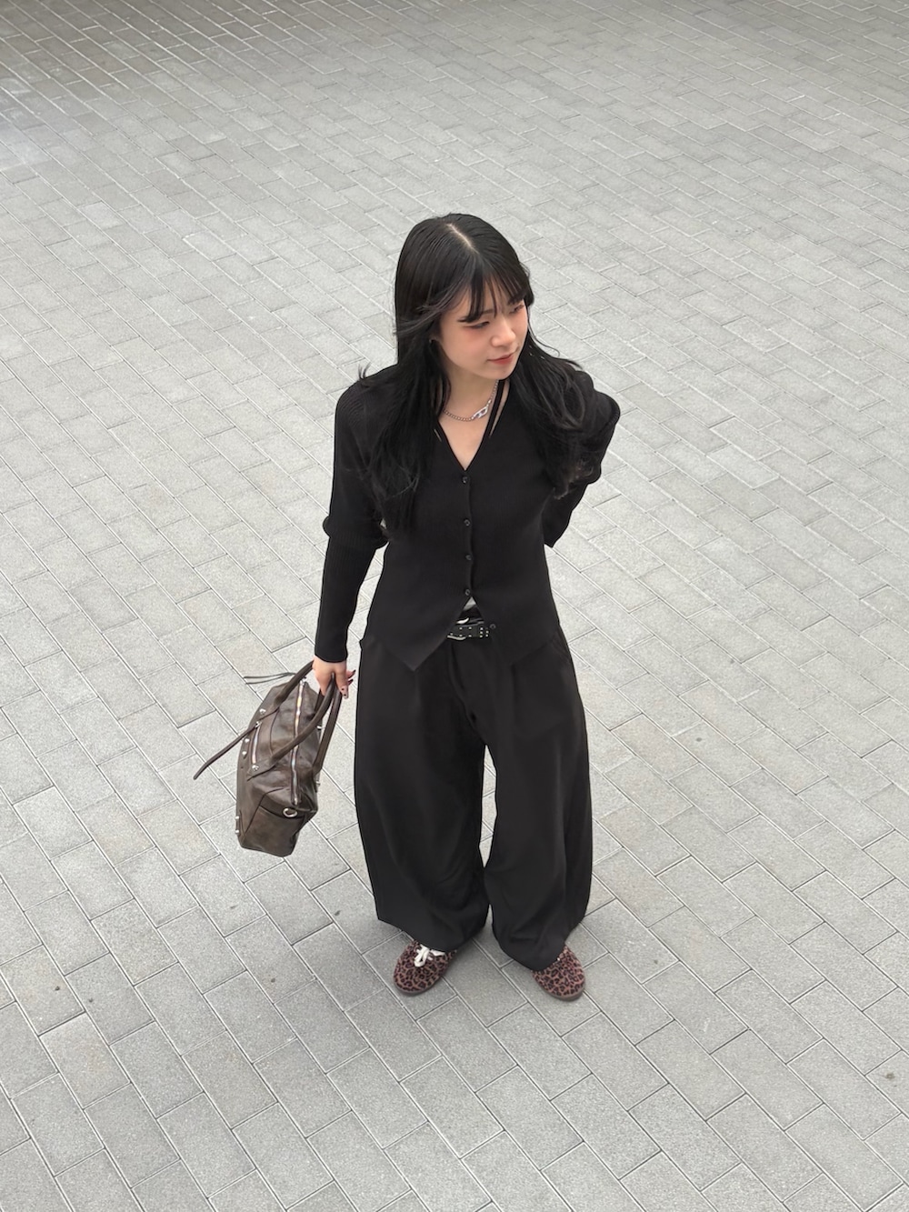ブラウン系のショルダーバッグ、ブラック系のカーディガン/ボレロ、ブラック系のスラックスを着用したレディースの春コーディネートの5枚目の写真